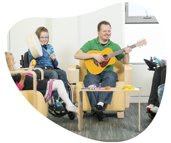 NDIS group centre activities featuring people playing guitar in chairs.