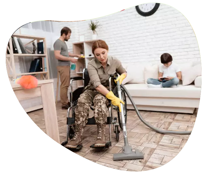 A woman in a wheelchair vacuuming a room as part of her NDIS household tasks.