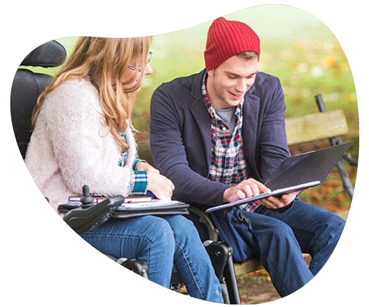 A man and a woman in wheelchairs sitting on a bench, receiving NDIS support coordination services.