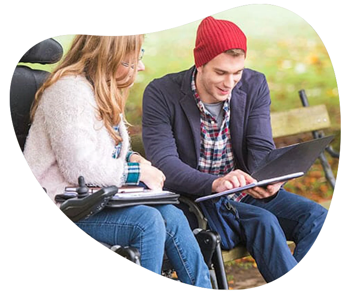 A man and a woman in wheelchairs sitting on a bench, receiving NDIS support coordination services. A man and a woman in wheelchairs sitting on a bench, receiving NDIS support coordination services.
